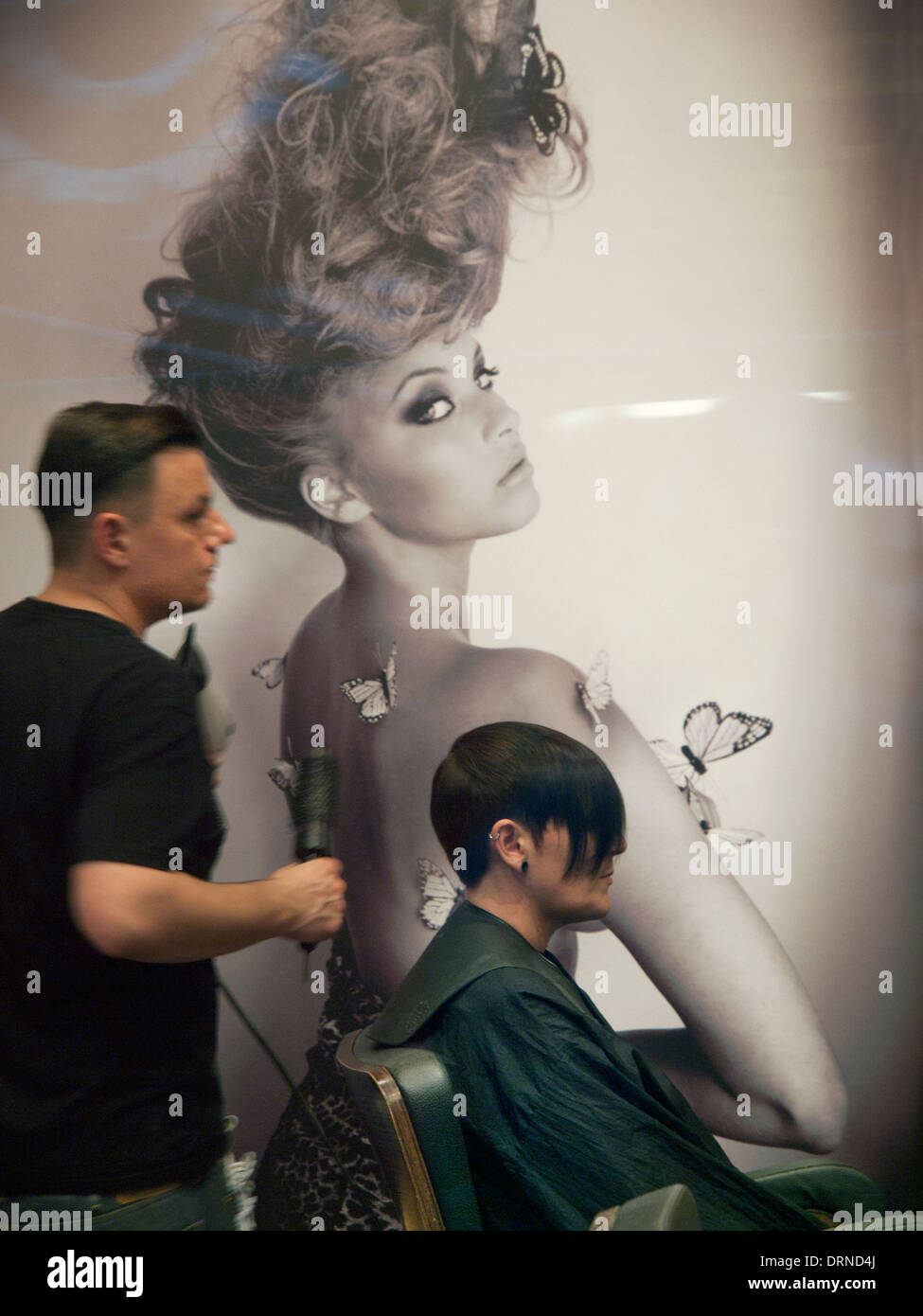 Ein Friseur bei der Arbeit mit einem Kunden Stockfoto