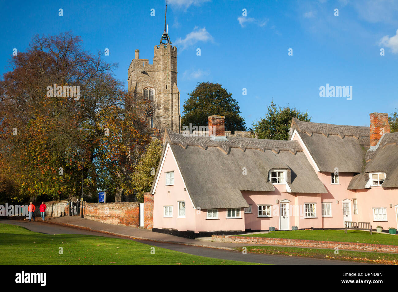 Die rosa Hütten unter Str. Marys Kirche, Cavendish, Suffolk, England. Stockfoto