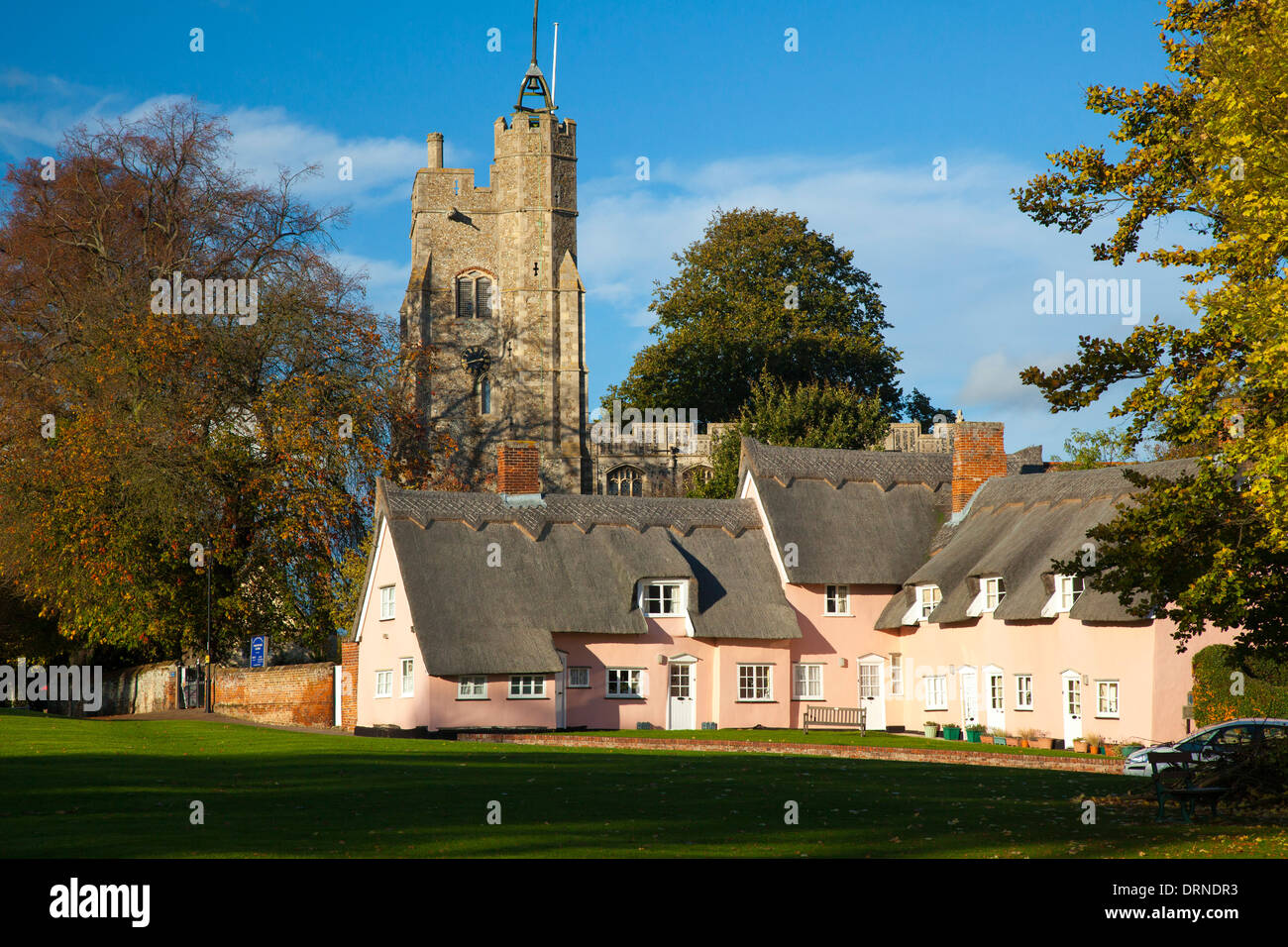 Die rosa Hütten unter Str. Marys Kirche, Cavendish, Suffolk, England. Stockfoto