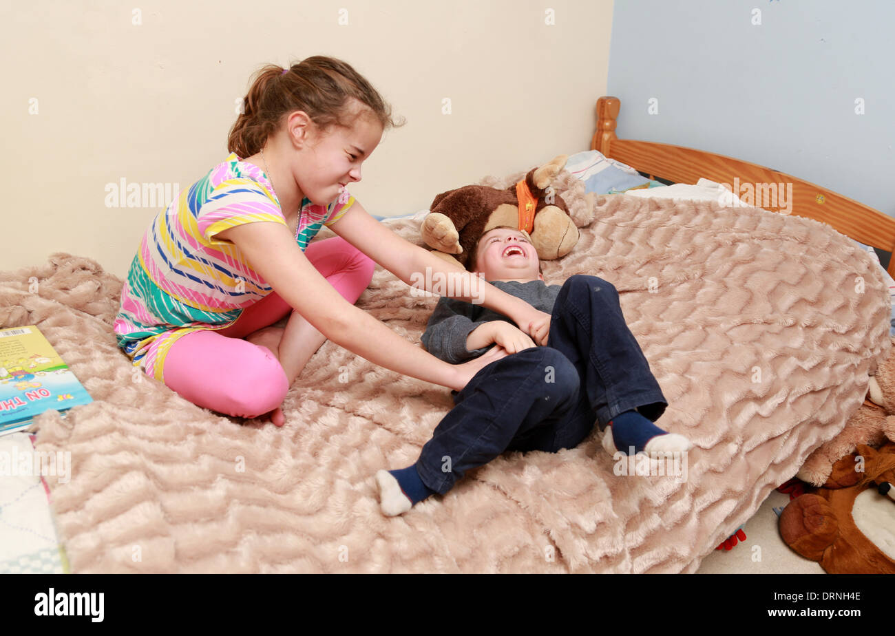 Kitzeln ihren jüngeren Bruder Schwester. Stockfoto