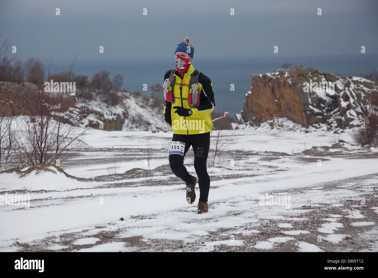 Ein Läufer macht seinen Weg durch den Schnee frühzeitig im Vorfeld. Stockfoto