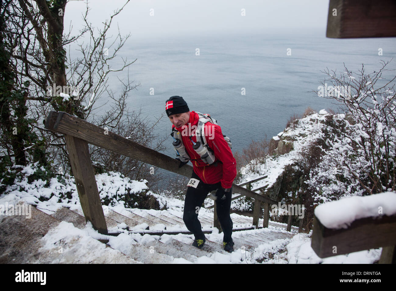 Ein männlicher 50 Meilen-Läufer kommt von Jons Kapel unten die Treppe hinauf. Die Treppen sind lang und hart, mit Schnee und Eis zu klettern. Stockfoto
