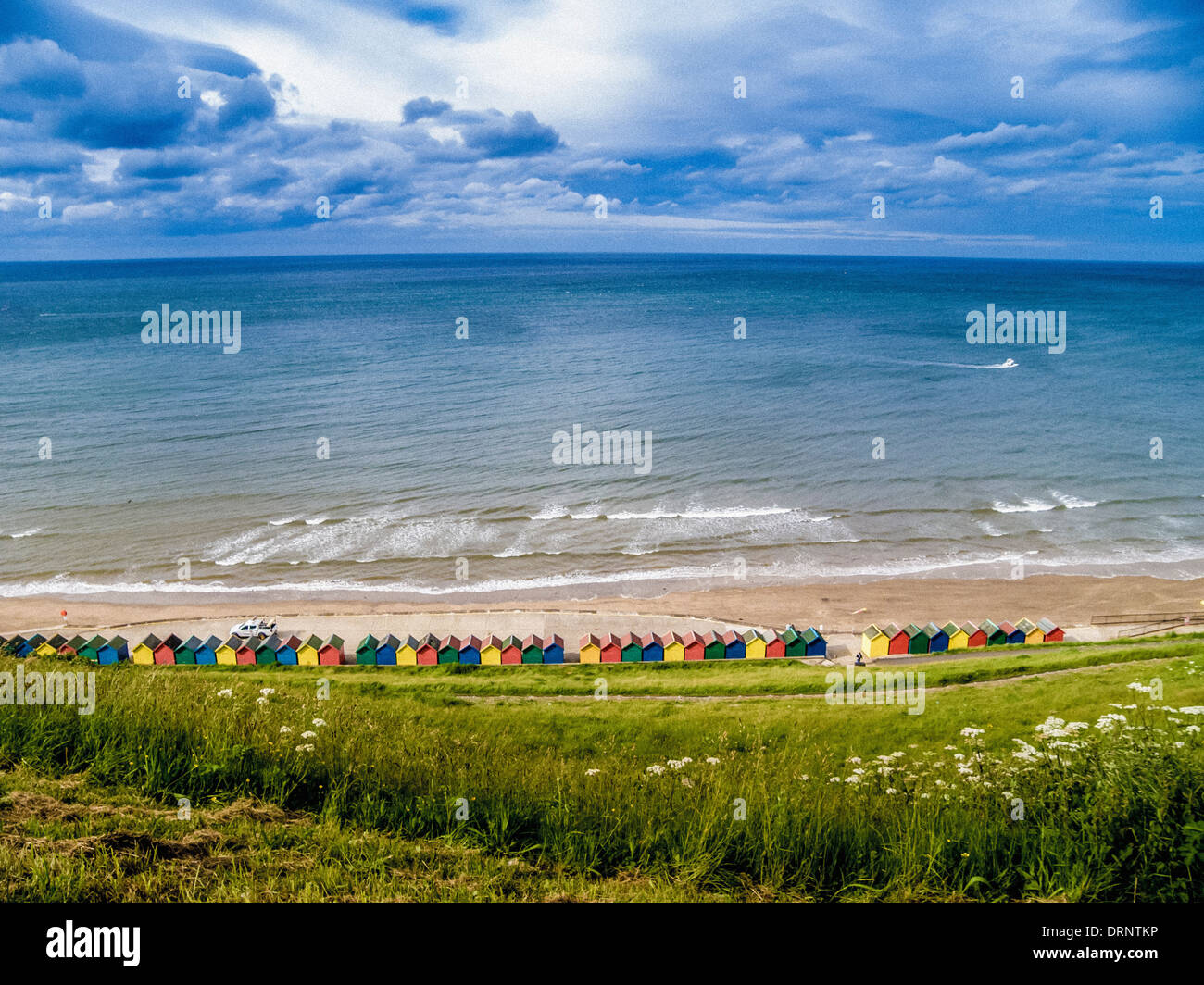 Bunte Strandhütten am Fuße des West Cliff, Whitby, North Yorkshire. Stockfoto