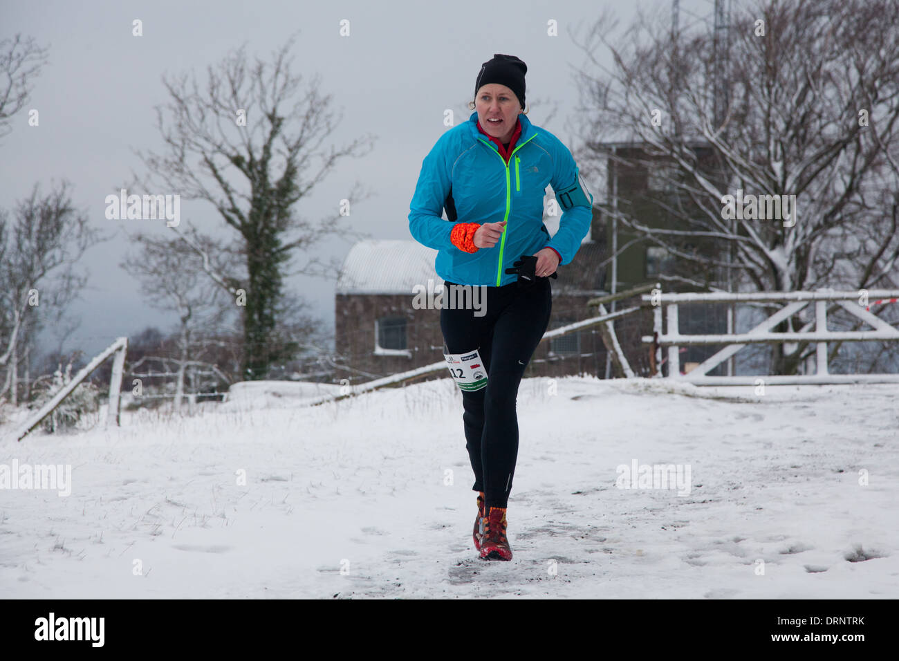 Ein Läufer macht ihren Weg über Hammer Knude nach Stunden hart laufen im Schnee. Stockfoto