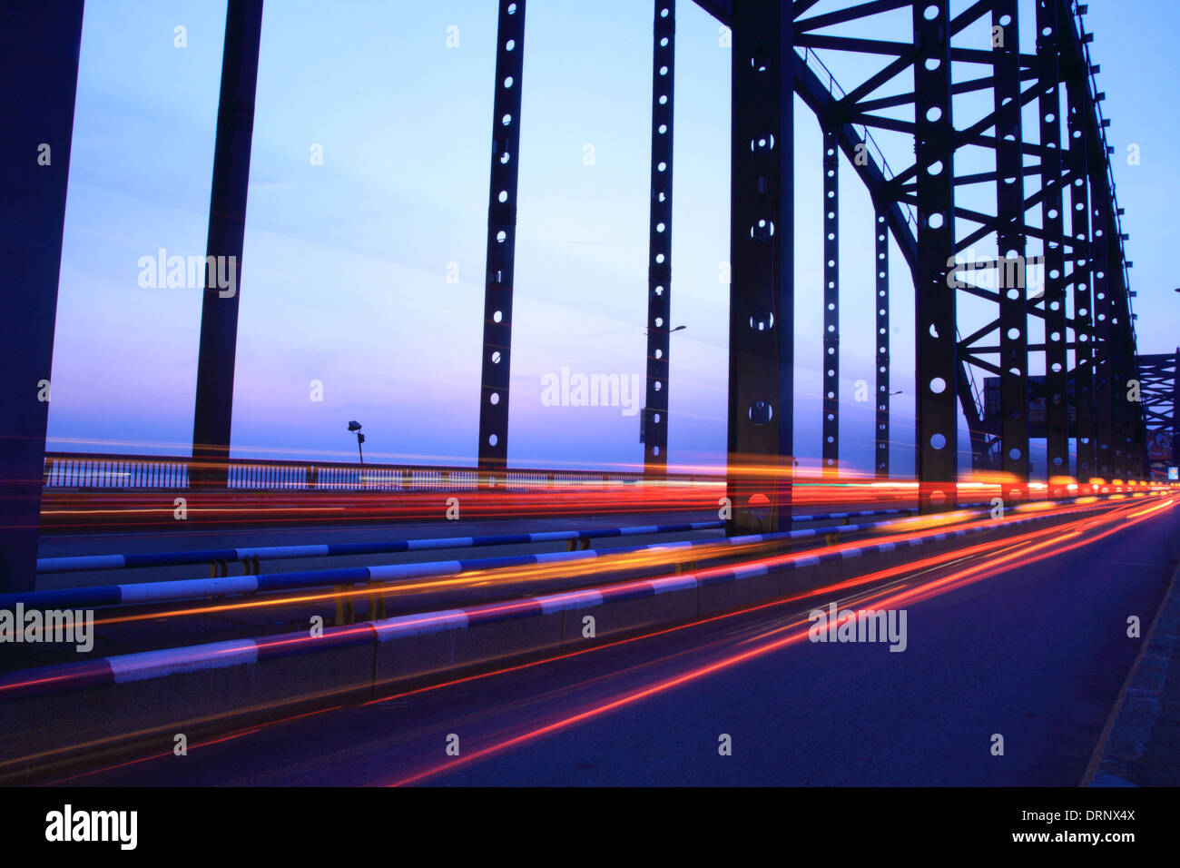Lichtspuren auf der Brücke in der Abenddämmerung Stockfoto