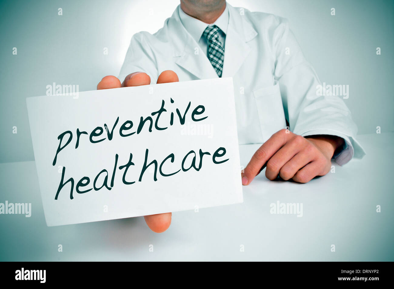 ein Mann trägt einen weißen Mantel zeigt ein Schild mit dem Text Gesundheitsvorsorge geschrieben Stockfoto