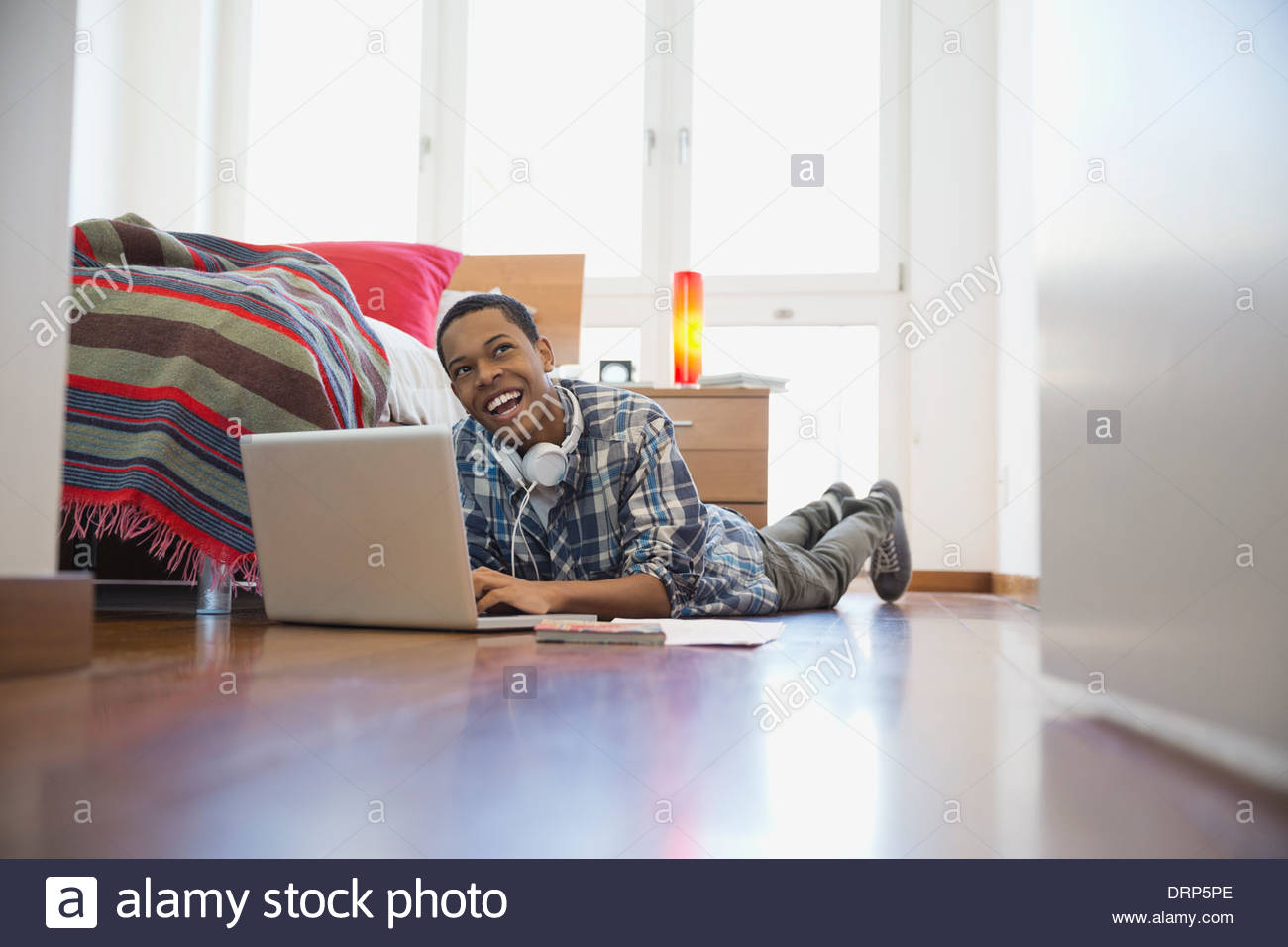 Teenager mit Laptop im Schlafzimmer Stockfoto