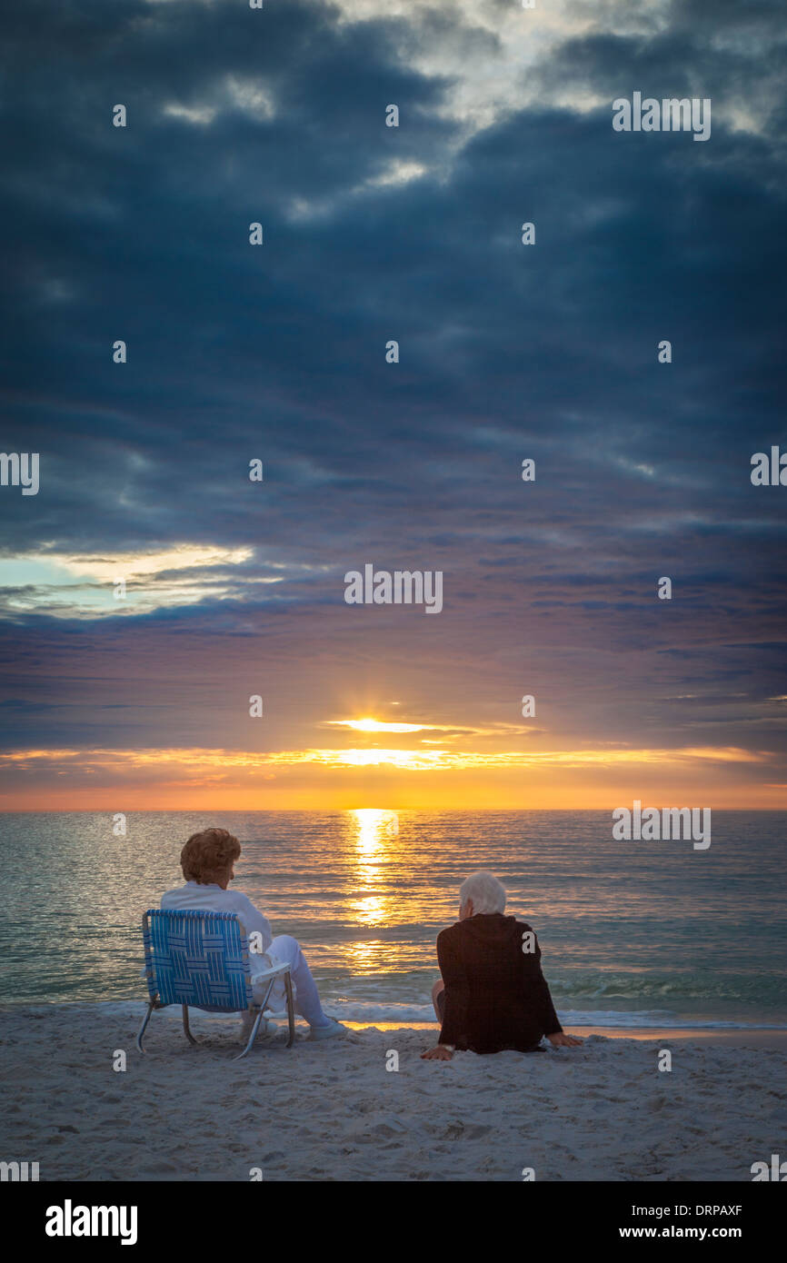 Zwei ältere Frauen, die einen Sonnenuntergang am Strand von Naples, Florida, USA Stockfoto