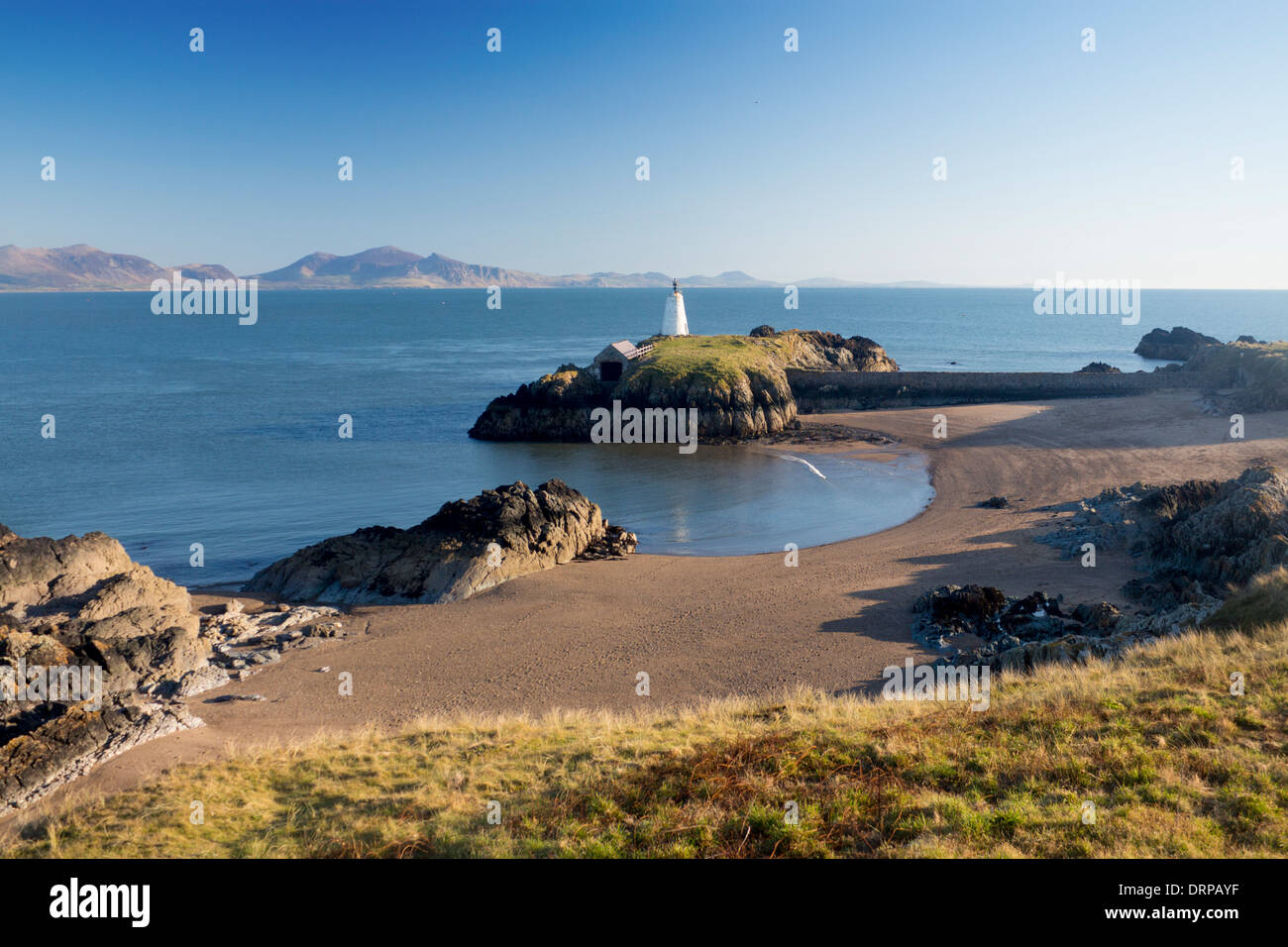 Llanddwyn Insel Ynys Llanddwyn Leuchtturm und Strand mit Cardigan Halbinsel Bergen im Hintergrund Anglesey North Wales UK Stockfoto