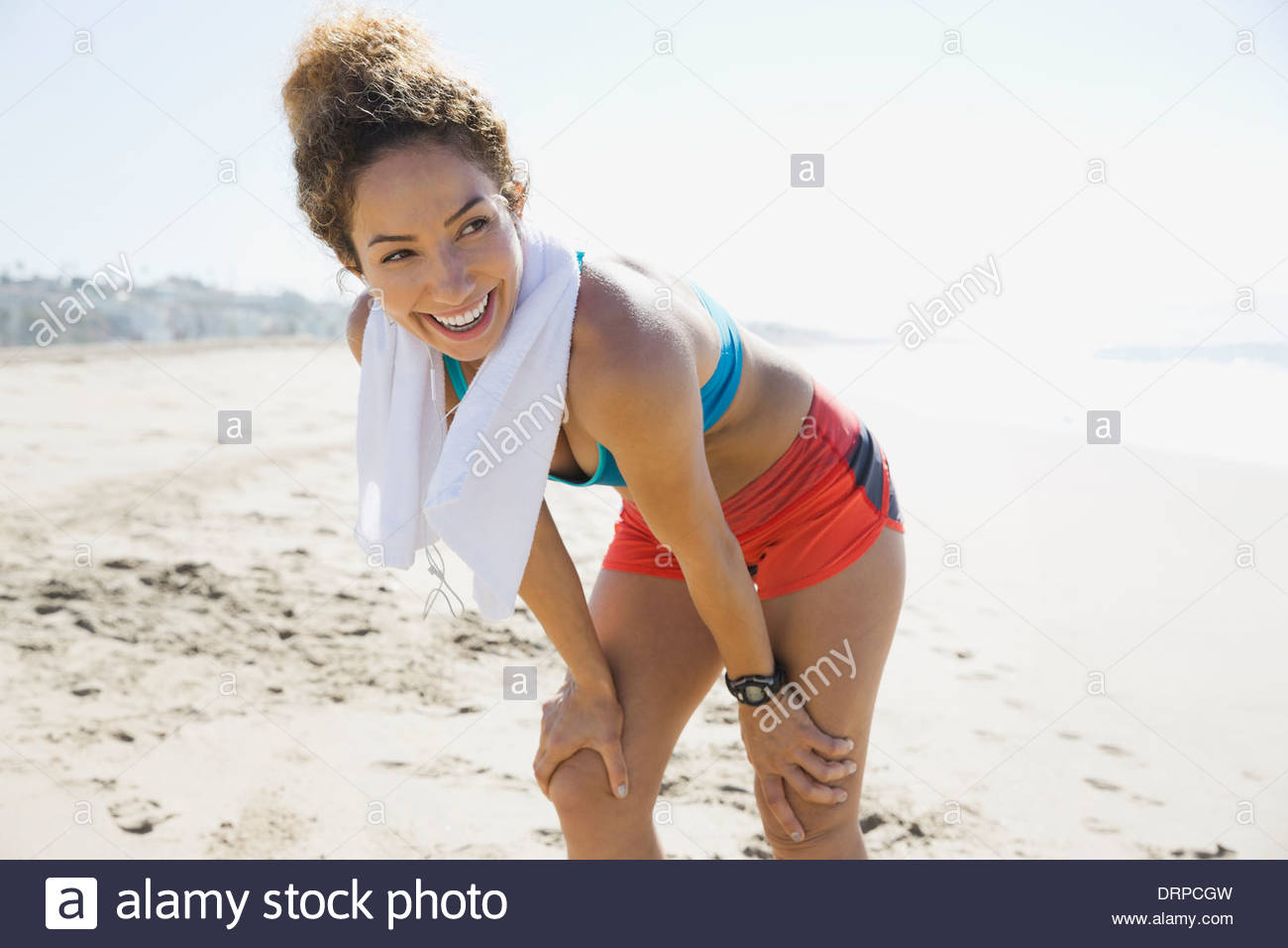 Aktive Frau, die Ruhe nach dem Training am Strand Stockfoto