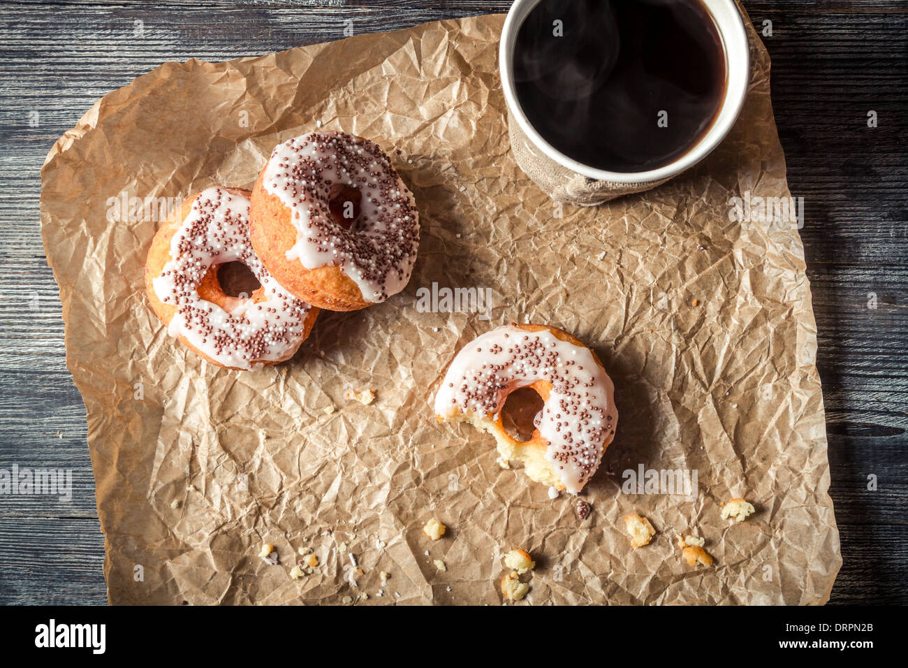 Heißer Kaffee und Donuts in das Papier gegeben Stockfoto