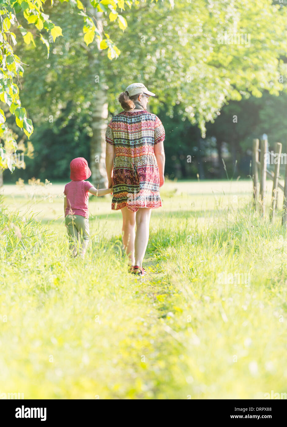 Kleine Mädchen und jede Frau, die zu Fuß in grüne Sommerlandschaft, Schweden Stockfoto