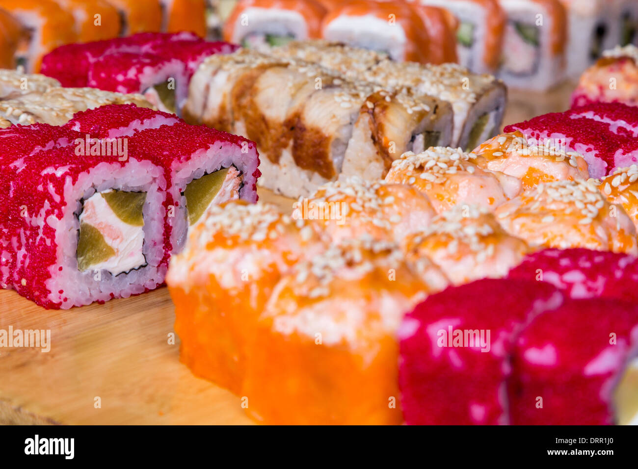 Sortiment-Sushi und Rollen auf Holzplatte in dunkles Licht Stockfoto