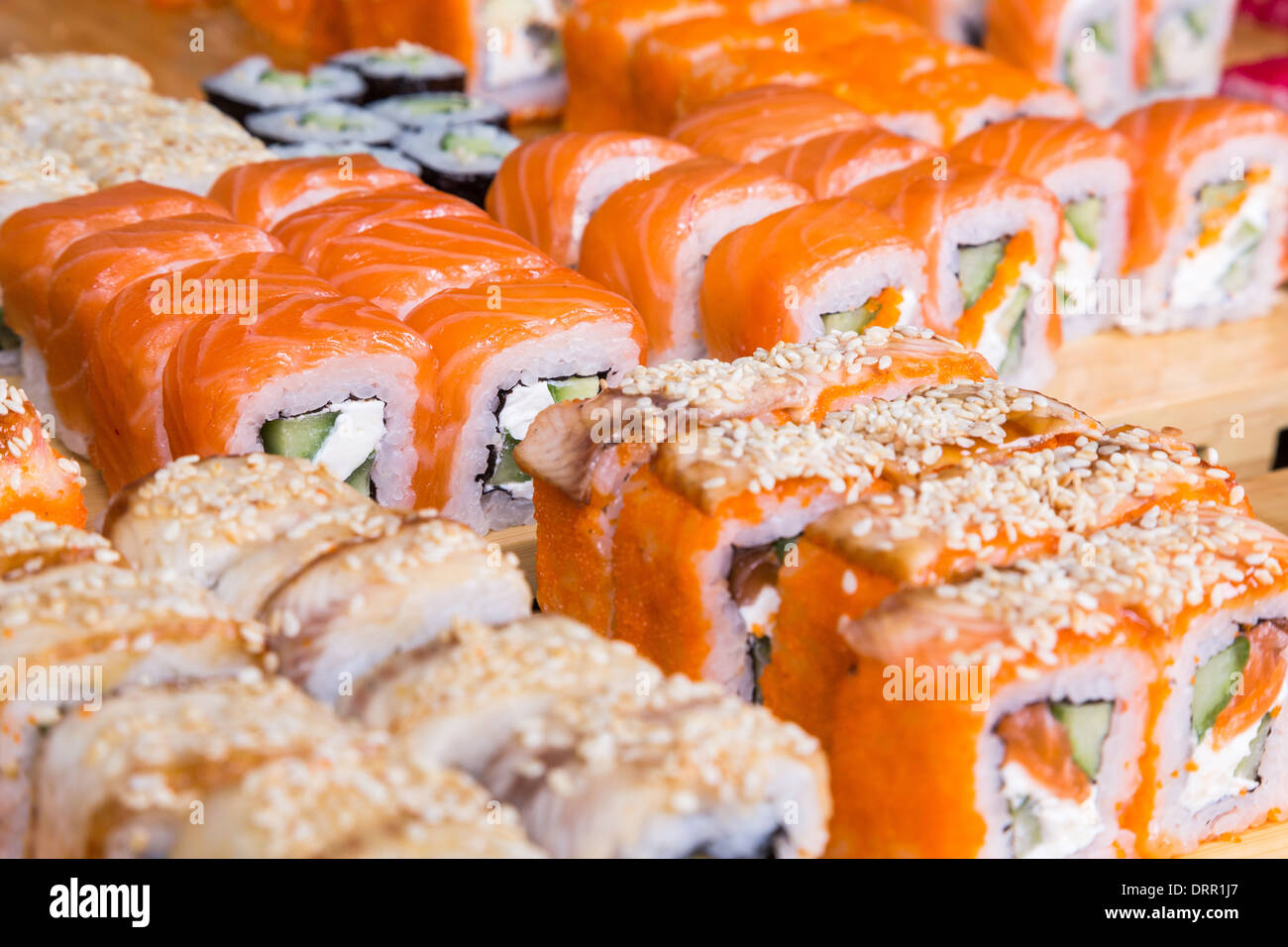Sortiment-Sushi und Rollen auf Holzplatte in dunkles Licht Stockfoto