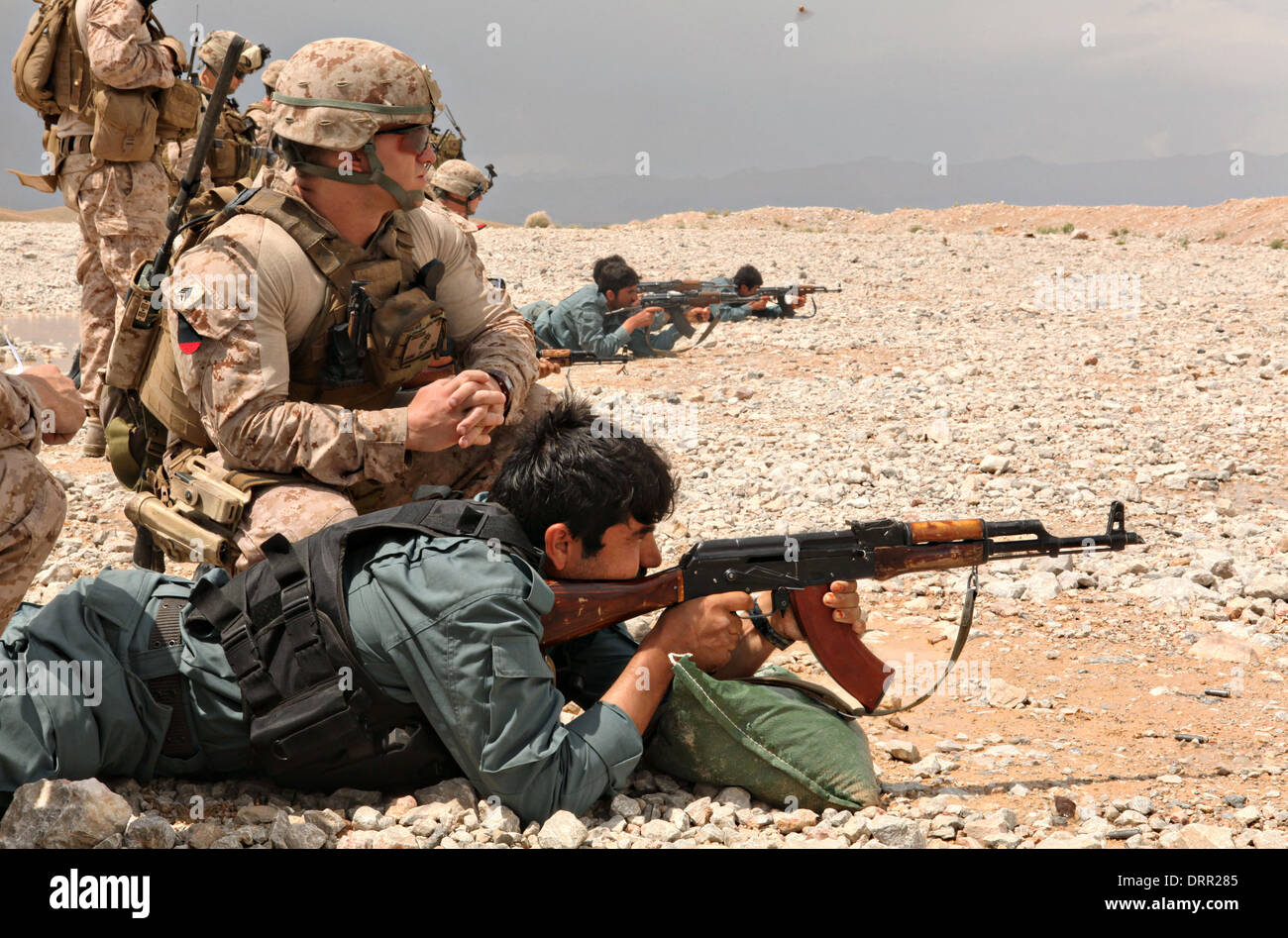 US Marine Corps Sgt. Joshua Vance Armstrong, coacht ein afghanischer Uniform Polizei Offizier während Gewehr Treffsicherheit trainieren 19. April 2012 auf Forward Operating Base Zeebrugge, Afghanistan. Stockfoto