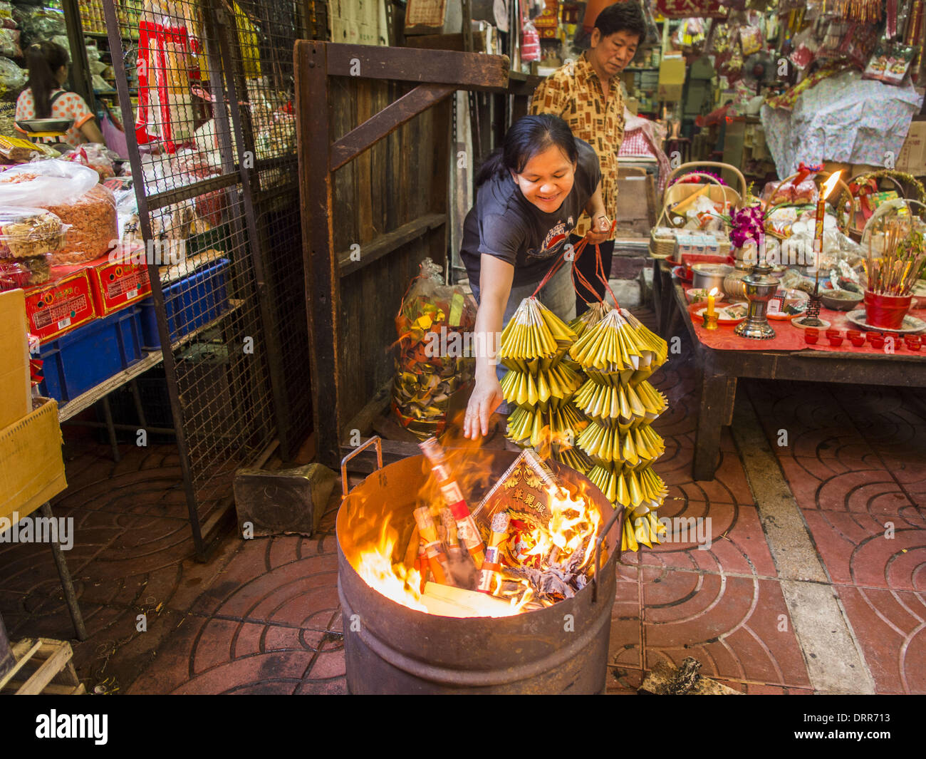 Bangkok, Thailand. 30. Januar 2014. Eine Frau brennt Opfergaben an die Götter zu beschwichtigen, während Lunar New Year Feierlichkeiten, auch bekannt als Tet und Chinese New Year, in Bangkok. Dieses Jahr ist das Jahr des Pferdes. Bildnachweis: Jack Kurtz/ZUMAPRESS.com/Alamy Live-Nachrichten Stockfoto