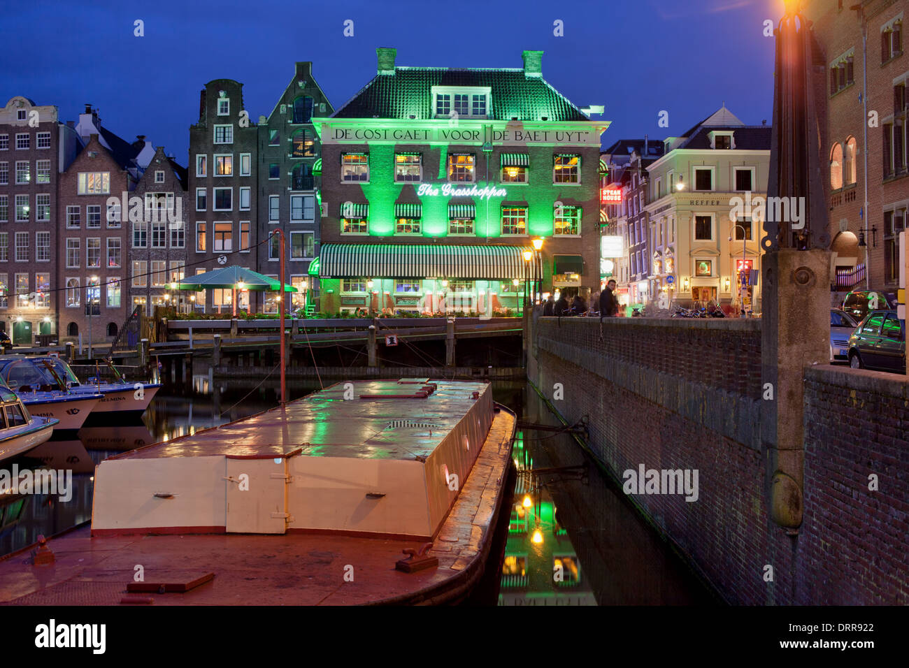 Amsterdam bei Nacht, Lastkahn auf einen Kanal und historischen Gebäuden in der Altstadt der Stadt, Nordholland, Niederlande. Stockfoto
