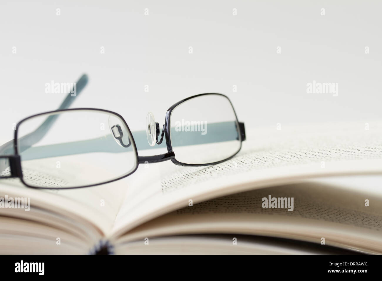 Brille auf ein offenes Buch mit geringen Schärfentiefe Stockfoto