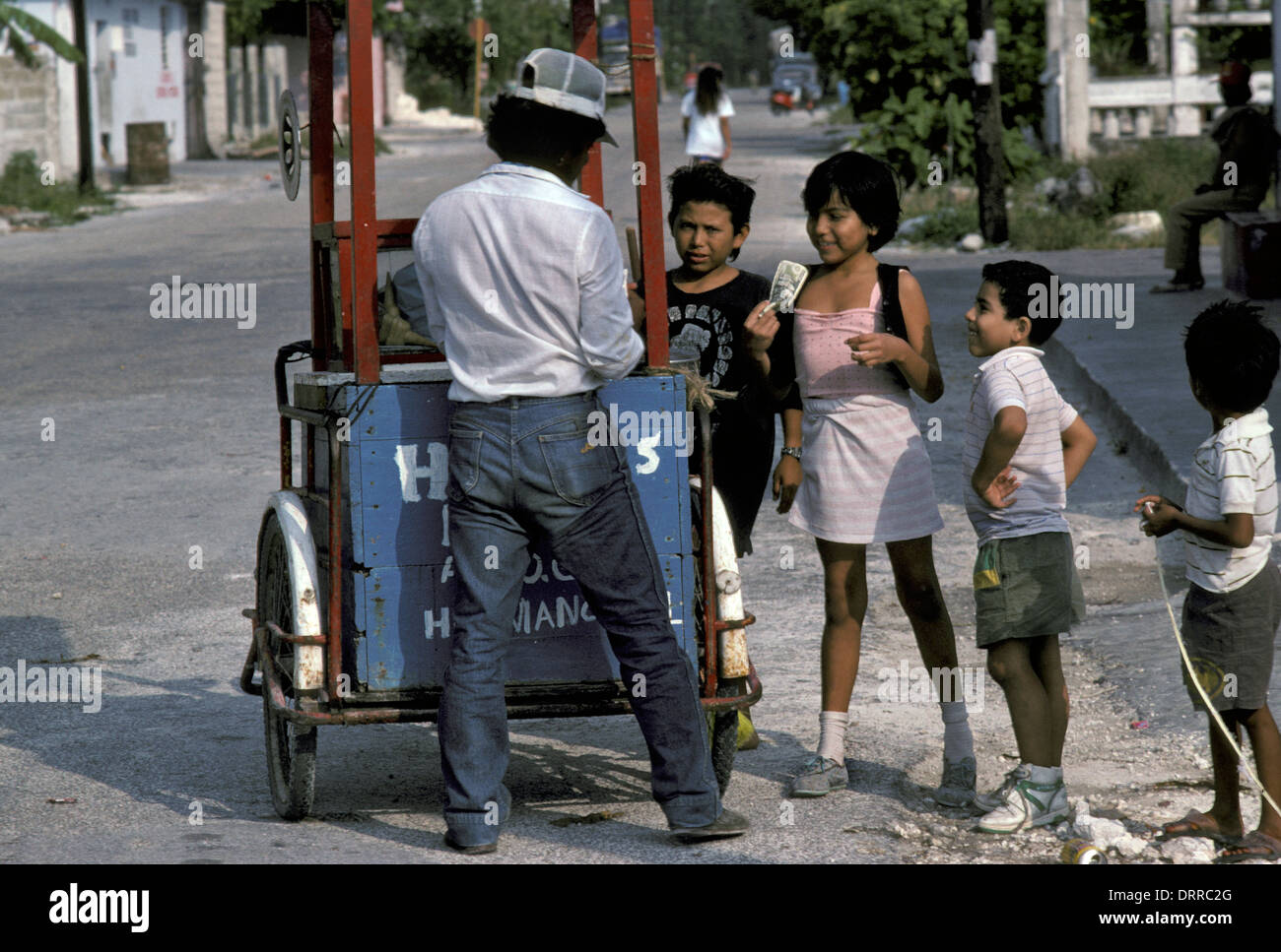 Kinder kaufen Eis von einem Straßenhändler auf der Insel Cozumel, Mexiko Stockfoto