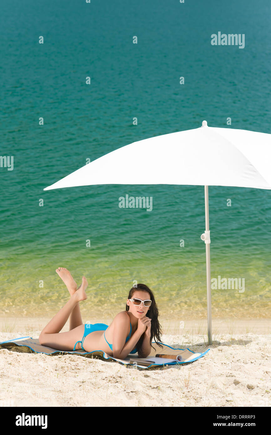 Sommer Strand Frau blauen Bikini unter Sonnenschirm Stockfoto