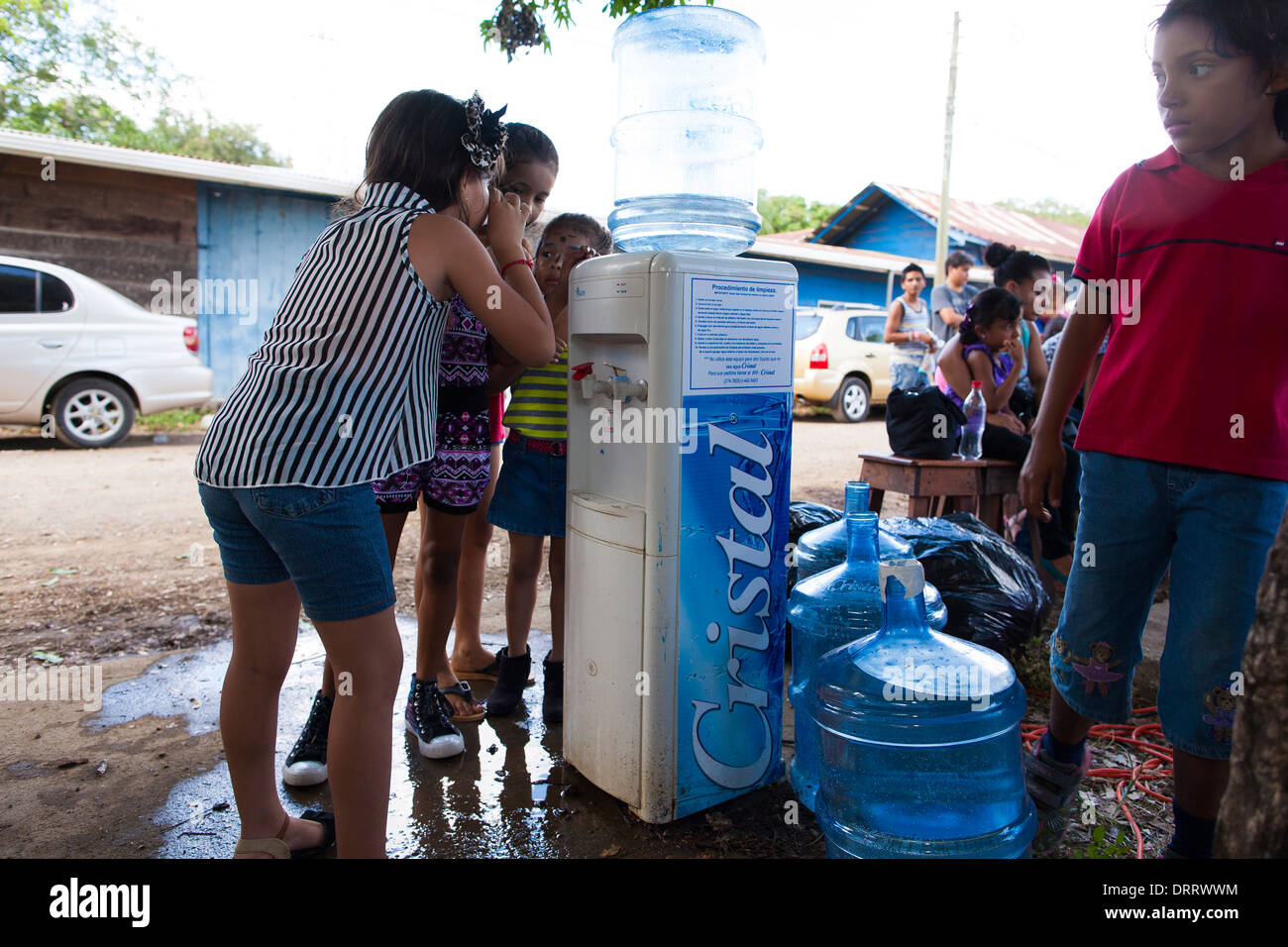 Kinder trinken Wasser aus einem Wasserspender bei einer gemeinschaftlichen Feier zu Weihnachten bei CEPIA in Huacas, Costa Rica Stockfoto