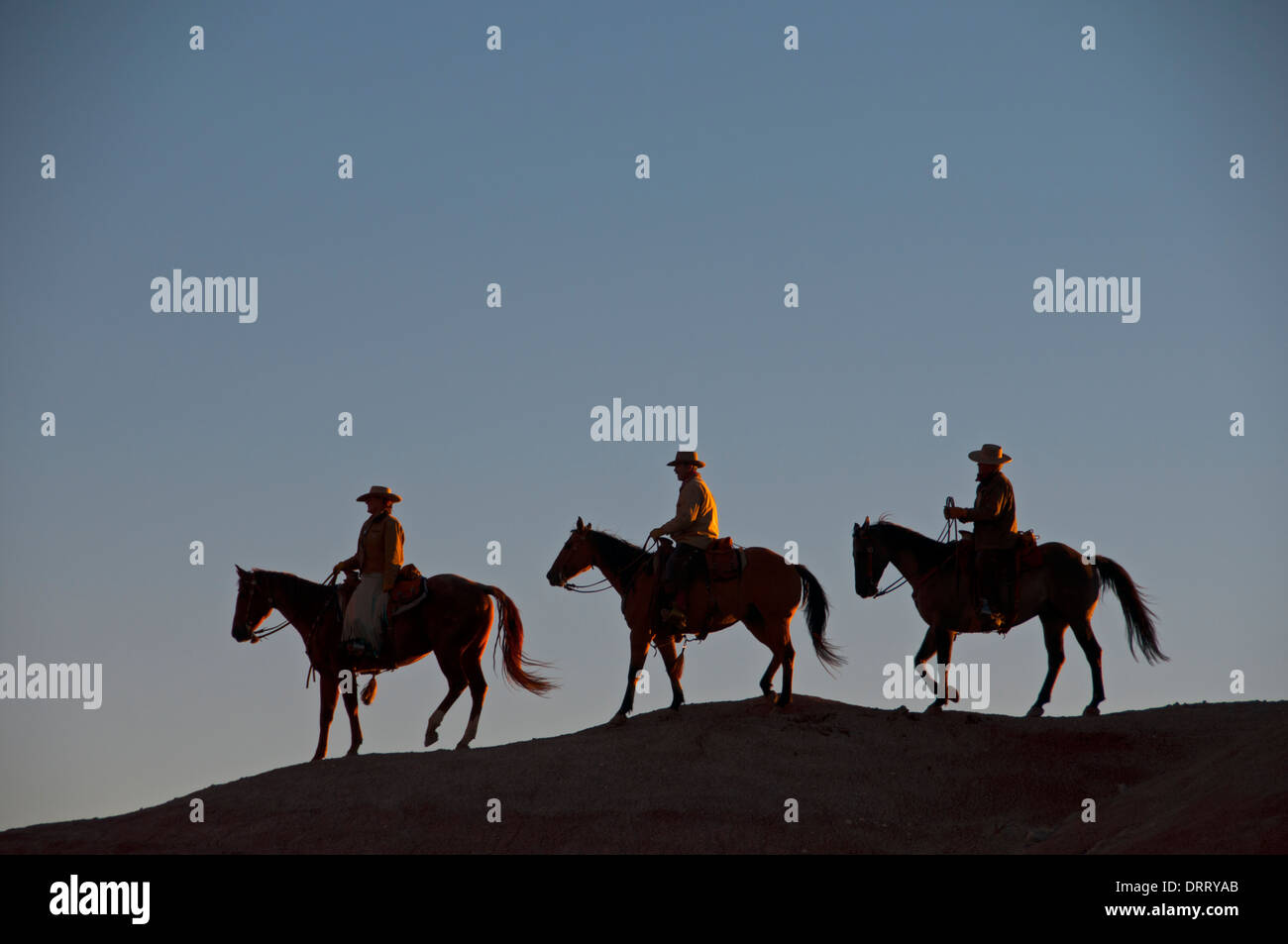 Drei Silhouette Cowboys zu Pferd nach Abschluss eine Pferd Round-Up in Painted Hills der Bighorn Mountains, Wyoming Stockfoto