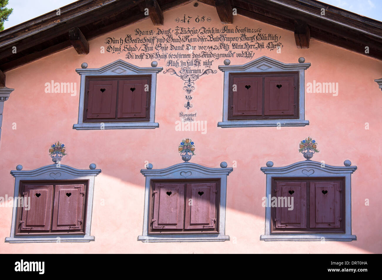 Fensterläden, Inschrift und Farbeffekte im 18. Jahrhundert Haus gebauten 1765 in Klosters, Graubünden, Schweiz Stockfoto