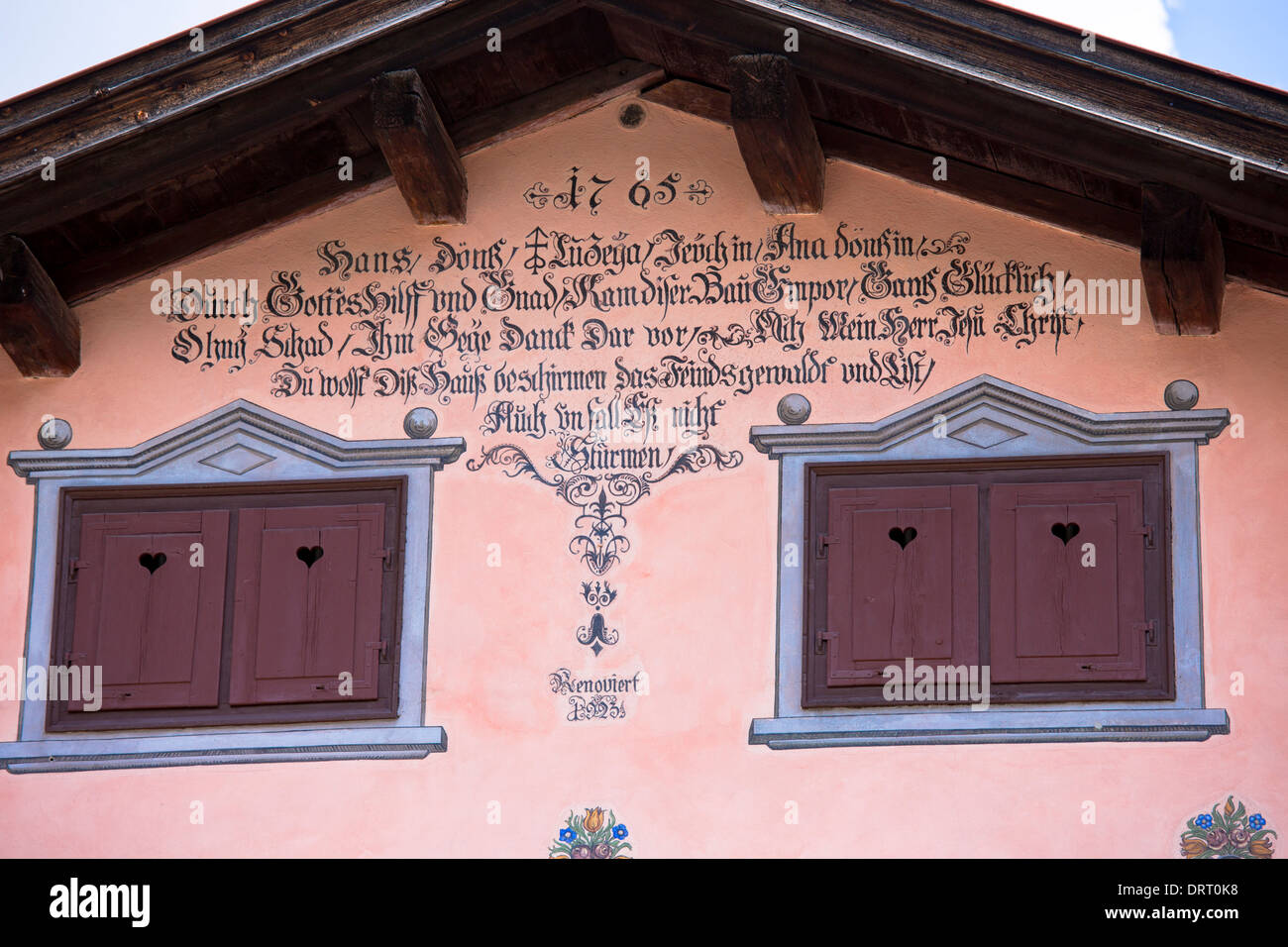 Fensterläden, Inschrift und Farbeffekte im 18. Jahrhundert Haus gebauten 1765 in Klosters, Graubünden, Schweiz Stockfoto