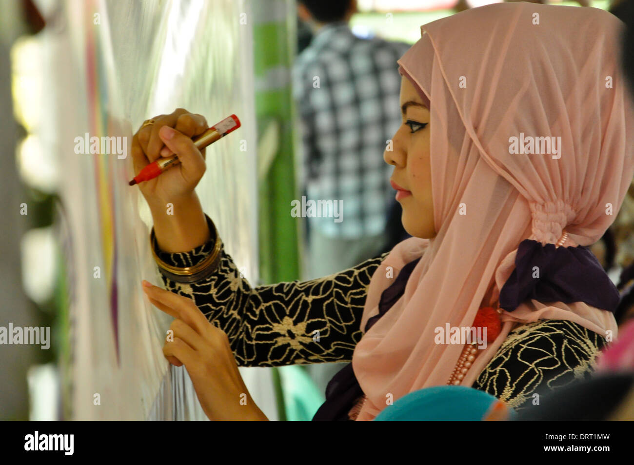 Ein Hijabi, Frau trägt ein Kopftuch, schreiben ihr Versprechen während der Feier des Welttages Hijab in Quezon City. Stockfoto