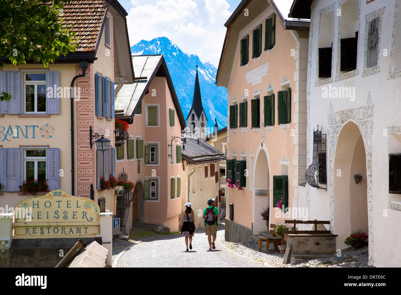 Touristen gehen Hotel Meisser im Engadin Dorf Guarda, gemalt von 17. Jahrhundert Steinbauten, Schweiz Stockfoto
