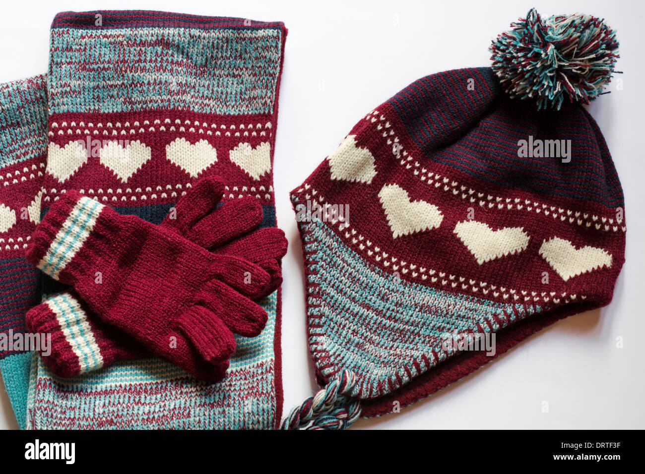 Mütze Handschuhe und Schal set mit Herzen auf setzen auf weißem Hintergrund Stockfoto