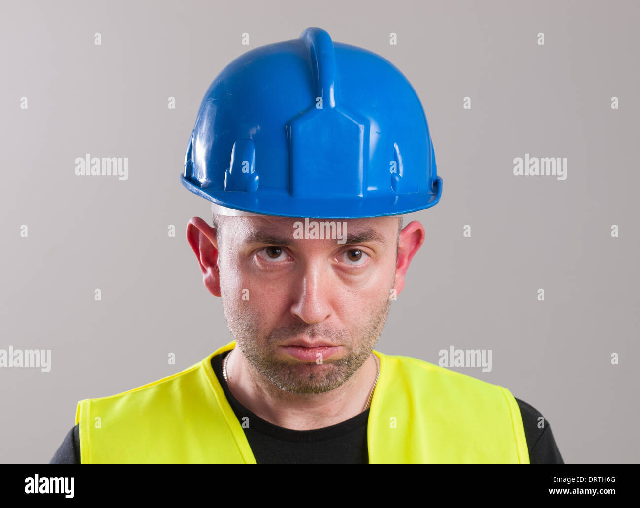 Porträt eines Arbeiters mit dem Ausdruck Negativität und isoliert auf dunklem Hintergrund Stockfoto