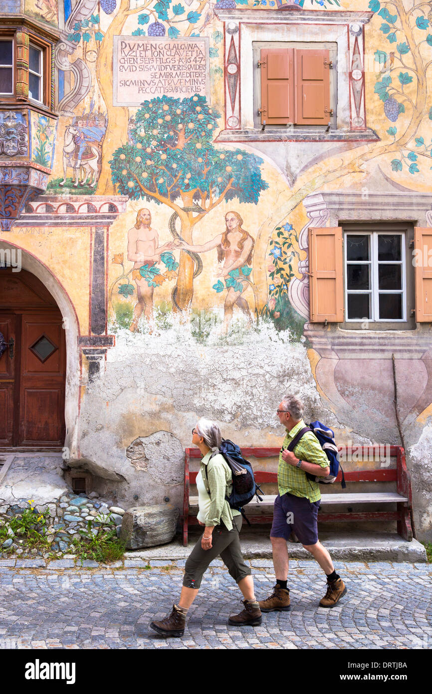 Touristen gehen Adam und Eve Wandbild in der Engadin Dorf Ardez mit bemalten 17. Jahrhundert beherbergt, Schweiz Stockfoto