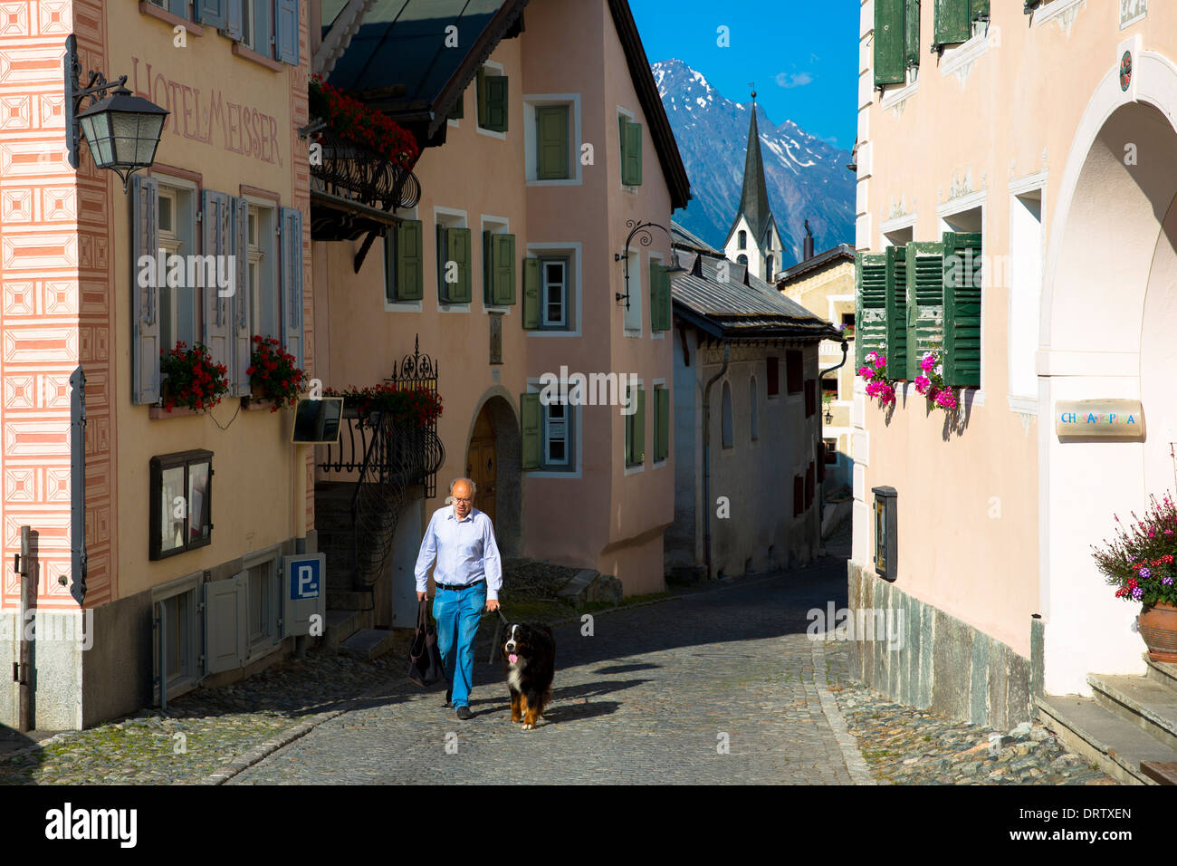Mann zu Fuß seine Berner Sennenhund im Engadin im Dorf Guarda in der Schweiz Stockfoto