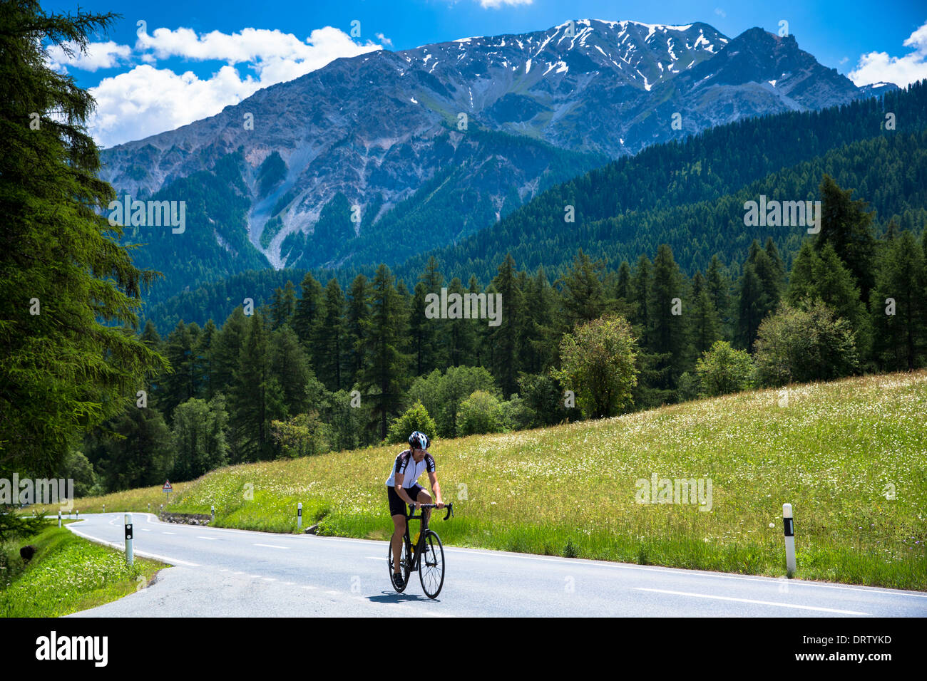 Radfahren bergauf im Schweizer Nationalpark mit Hintergrund der Schweizer Alpen, Schweiz Stockfoto