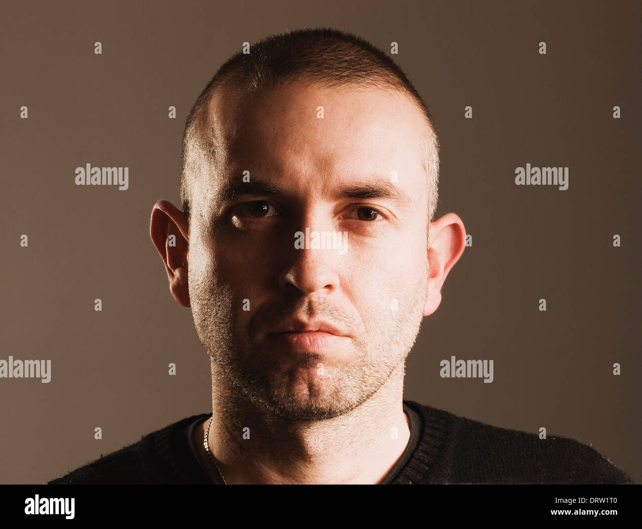 Mann mit Ernst Ausdruck, auf der Suche und Kamera und dunklem Hintergrund isoliert Stockfoto