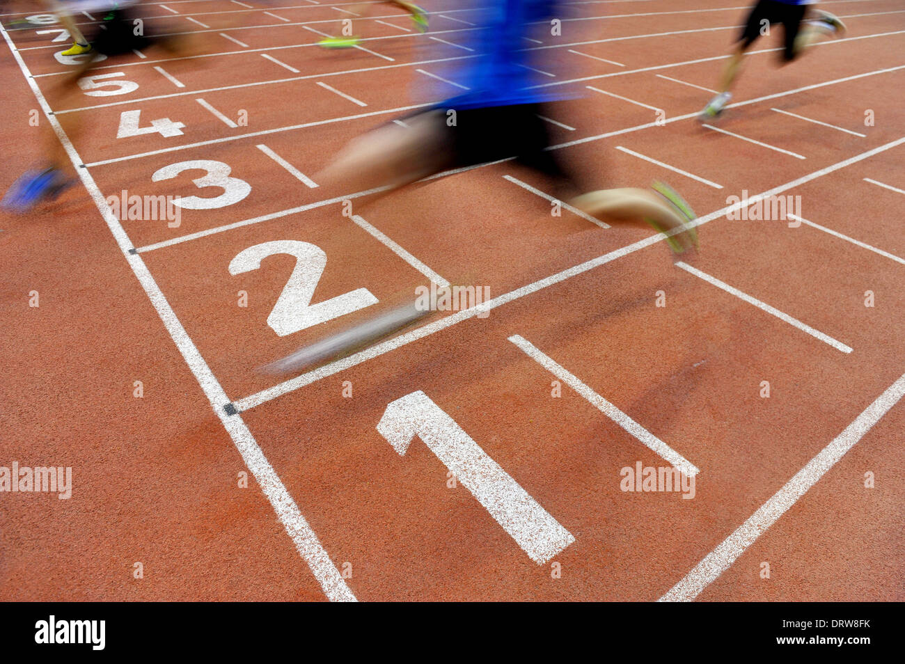 Verschwommene Athleten durch eine langsame Kamera Verschlusszeit sind nach Sprint Track die Ziellinie überqueren. Stockfoto
