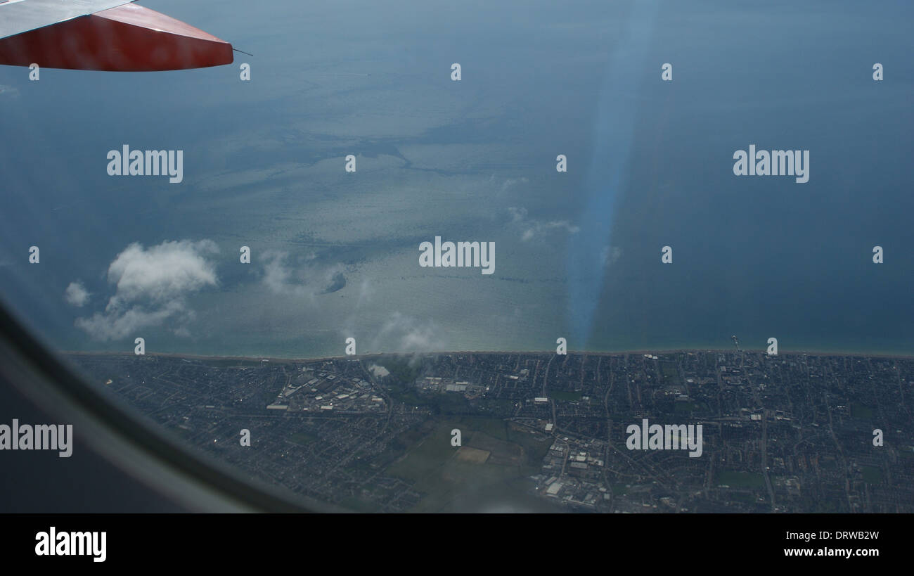 Flugzeug Fenster Ansicht Küste Linie Wolke Sea Land Boden Stockfoto