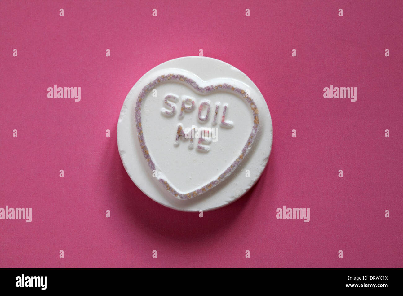 Swizzels Matlow Giant Love Hearts - individuell süß mit Verwöhnung mich isoliert auf rosa Hintergrund - Valentinstag-Nachricht - liebensüße Stockfoto