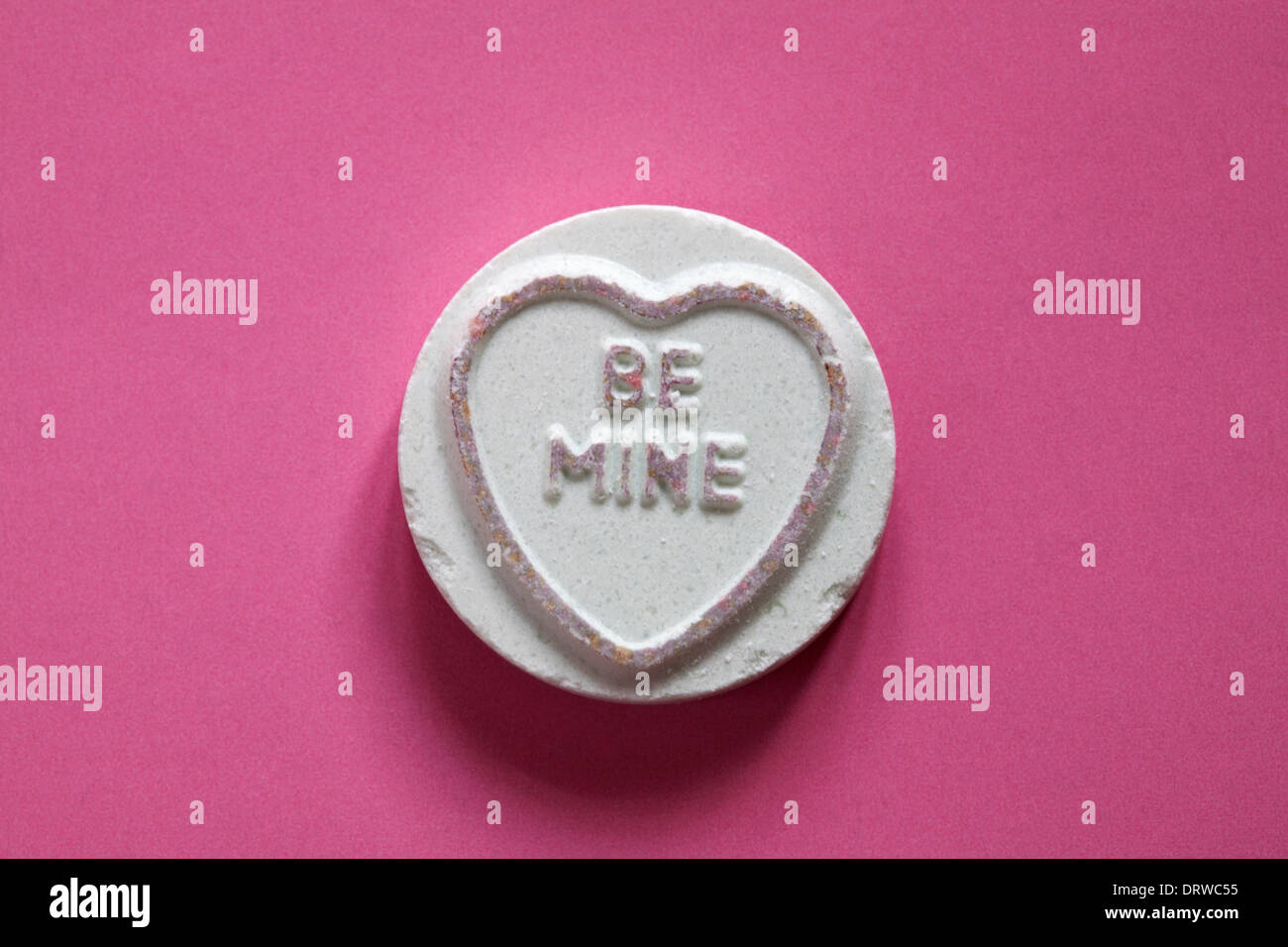 Swizzels Matlow Giant Love Hearts - individuell süß mit Be Mine auf rosa Hintergrund isoliert - Valentinstag-Nachricht - liebensüße Stockfoto