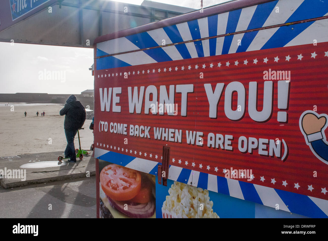 Wir möchten, dass Sie. Mann auf Roller sieht bei Porthcawl Hafen mit Fast food Kiosk im Vordergrund. Stockfoto