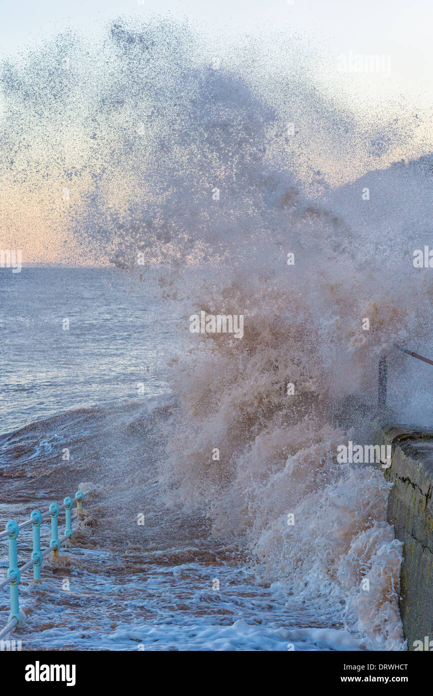 Wellen brechen gegen den Deich am östlichen Ende von Blue Anchor Bay bei Flut am Morgen des 1. Februar 2014 Stockfoto