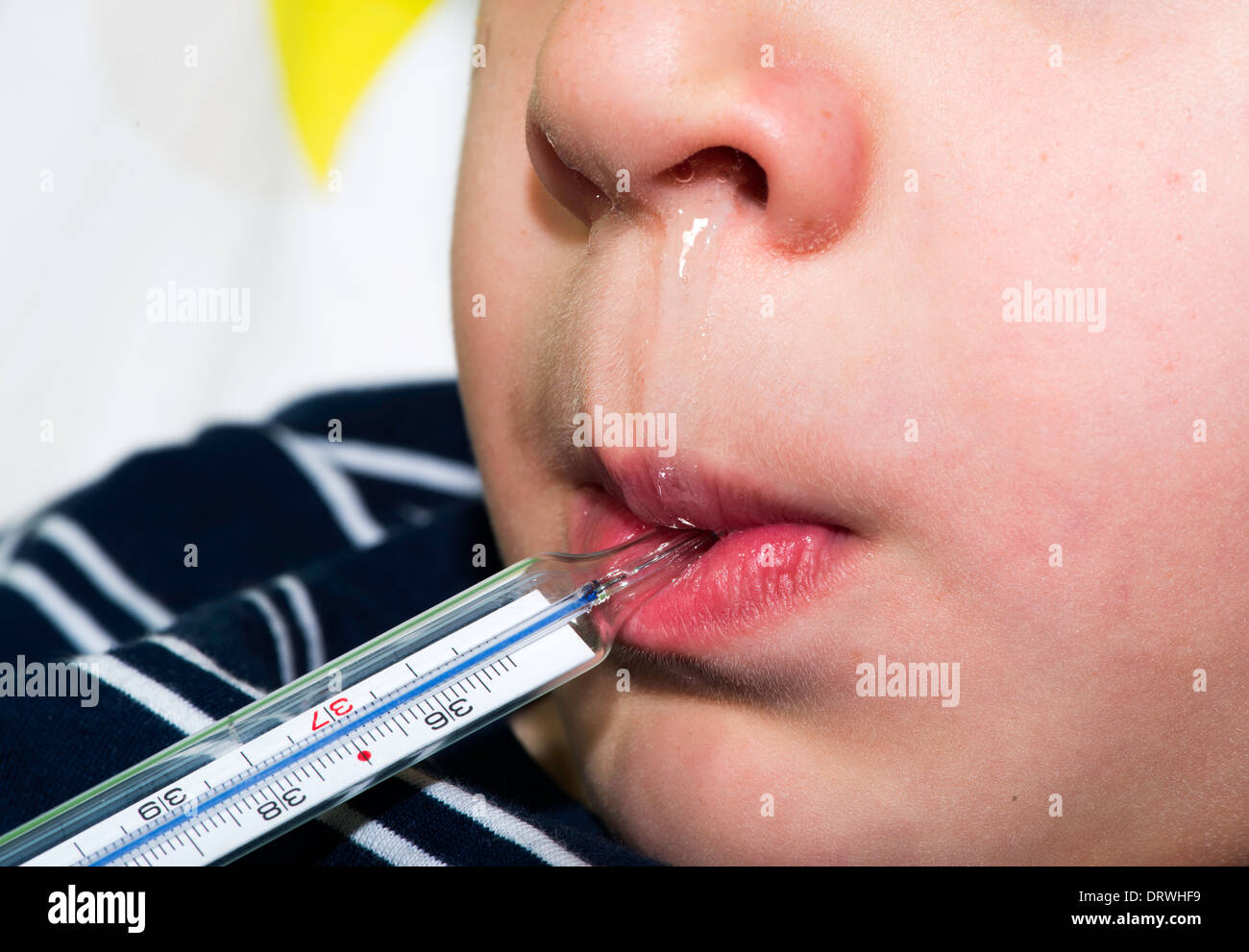 Krankes Kind im Bett. Messen Sie die Temperatur mit einem Thermometer. Stockfoto