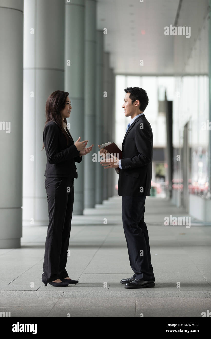 Glücklich chinesischen Geschäftspartnern außerhalb des Büros miteinander zu reden. Stockfoto