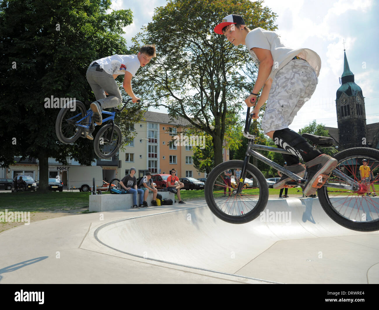 Zwei junge Biker springen mit ihren Fahrrädern auf einem städtischen Bike Park. Stockfoto