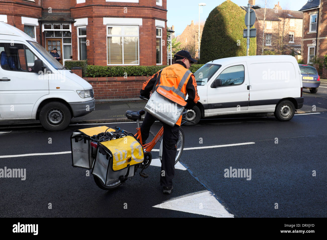 ein tnt Lieferung Mann auf einem Fahrrad mit Packtaschen für seinen Posten Stockfoto