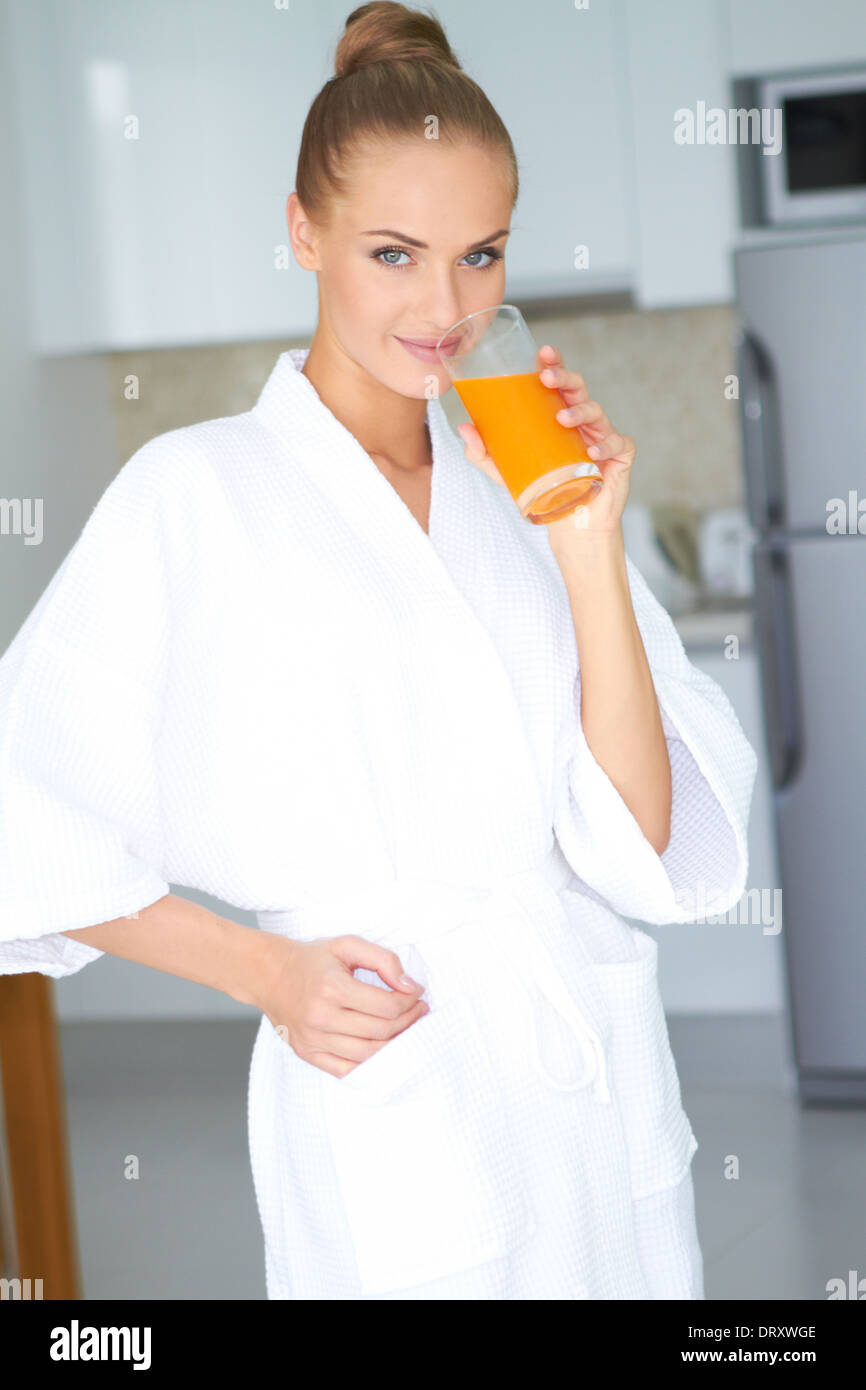 Frau im Bademantel Orangensaft trinken Stockfoto