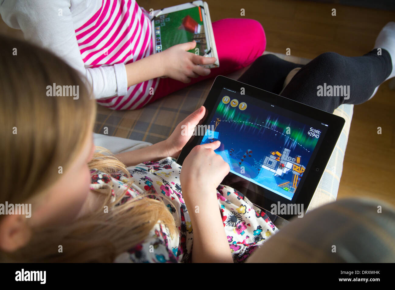 Zwei Schwestern spielen auf iPads Stockfoto
