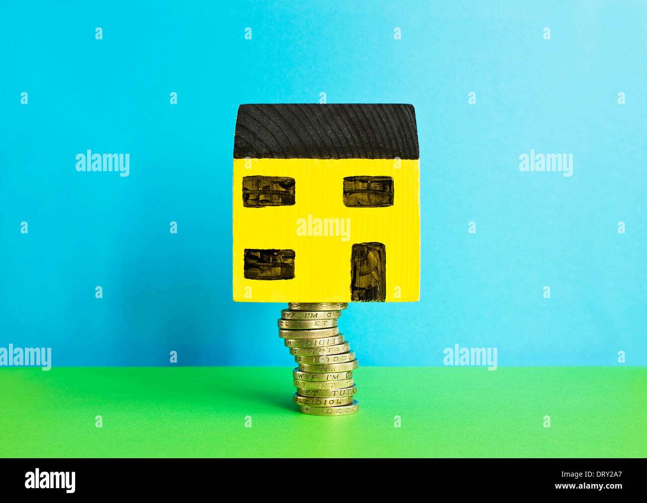Spielzeug-Haus auf einem Pfund-Münzen Stockfoto