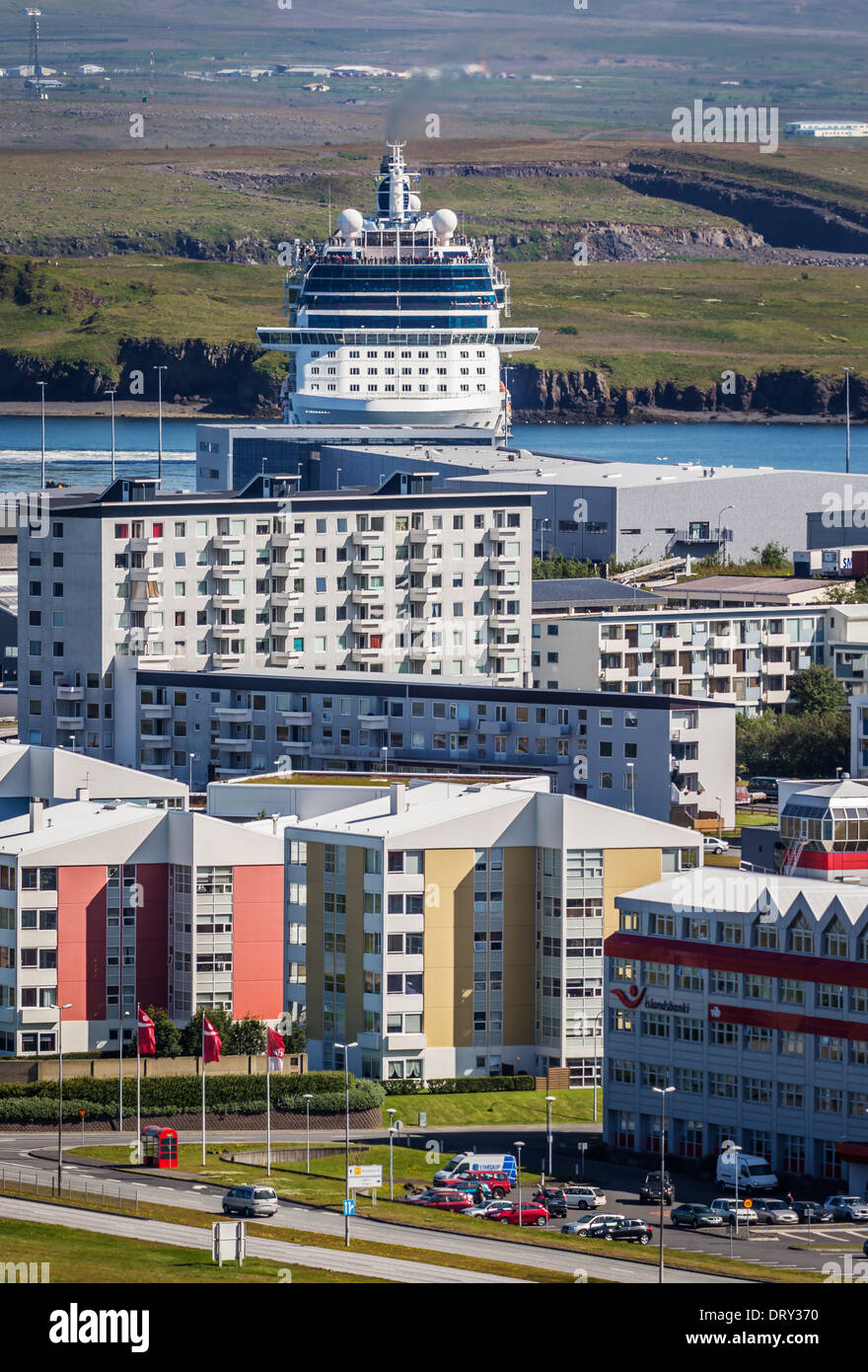 Mehrfamilienhäuser mit einem großen Kreuzfahrtschiff im Hafen, Reykjavik, Island Stockfoto